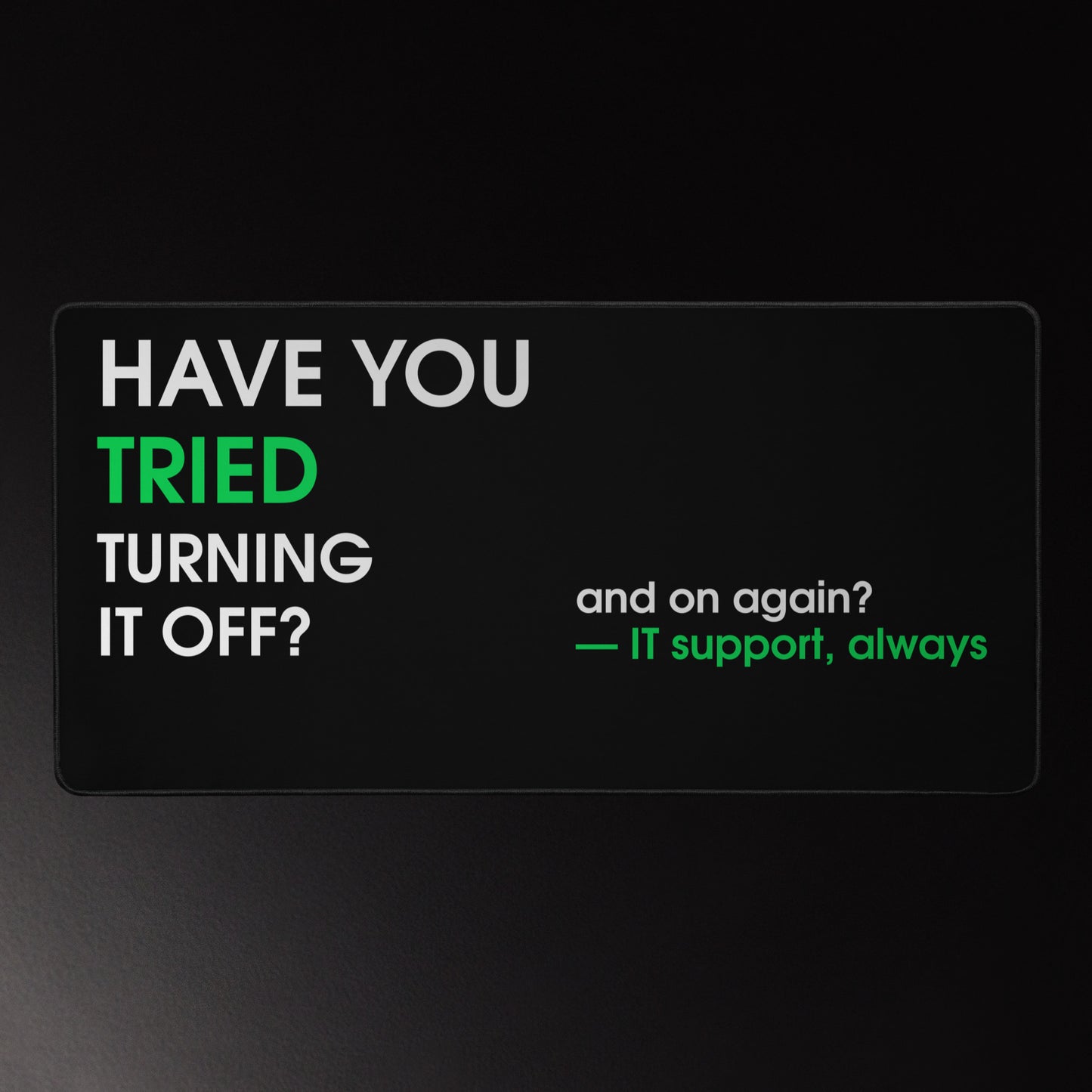 IT support desk mat on black with white and green bold typography reading Have You Tried Turning It Off and On Again