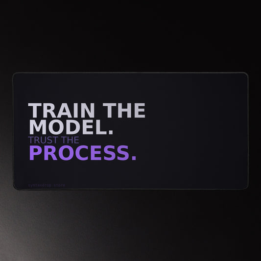 ML engineer desk mat on near-black background reading "TRAIN THE MODEL. Trust the PROCESS." in lavender-white and violet bold typography, left-anchored with wide negative space