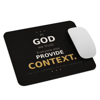 Prompt engineer mouse pad on cream background with bold black and gold typography reading In God We Trust Everyone Else Provide Context