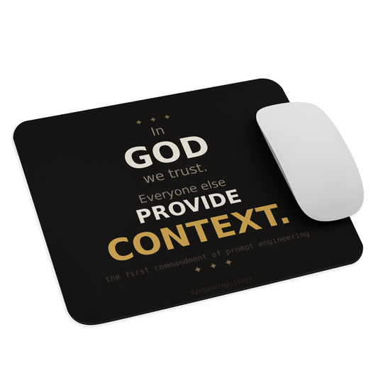 Prompt engineer mouse pad on cream background with bold black and gold typography reading In God We Trust Everyone Else Provide Context